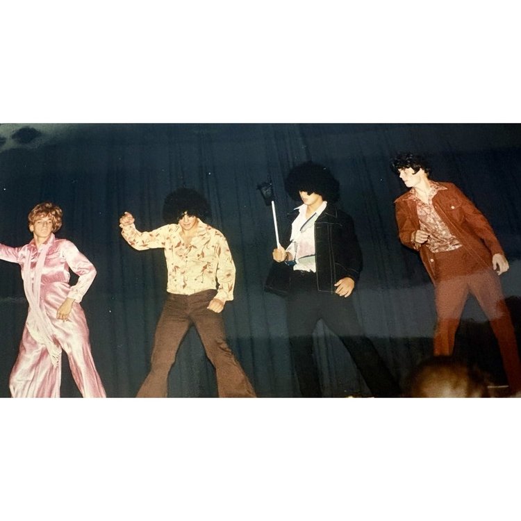 BKHS classmates in '70s disco costumes performing a dance number on stage, 1996